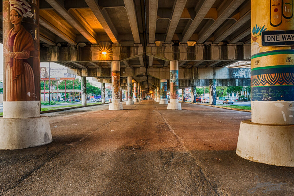 Historical tour in the city of New Orleans shows an image underneath a bridge of the rich visual culture of New Orleans - the bottoms of the bridge is covered in colorful street art and grafiti.