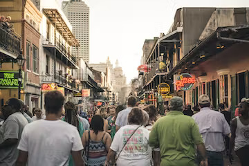 Featuring people gathering in the streets of historic downtown New Orleans to tour historical homes and pubs on the haunted pub crawl.