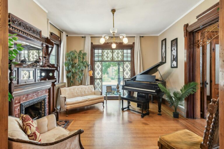 Charming sitting room in the Harry F. Legg House, designed for relaxation with cozy furnishings, intricate details, and views of the surrounding neighborhood.