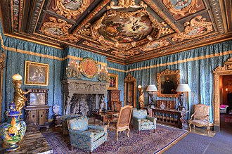 Lavishly decorated sitting room at Hearst Castle, featuring antique furniture, detailed ceilings, and historic artwork.
