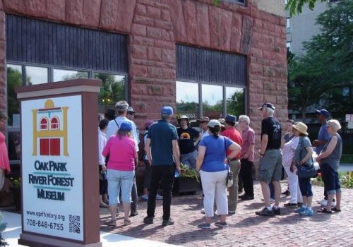 Visitors in Oak Park enjoy a walking tour on a sunny day around the historic homes of the city.
