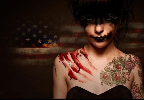 Pictured here is a woman, with her eyes covered by a shadow and her shoulder covered in blood, representing the darker history of Philadelphia and the nontraditional tours given by this tour company that are not family-friendly, that allow visitors to get to know the real history of philadelphia.