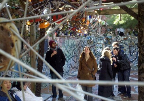A great historical tour of Philadelphia is pictured here, that allows visitors to explore the murals and public art on the south side of the city, as the group is doing on a sunny day in this image.